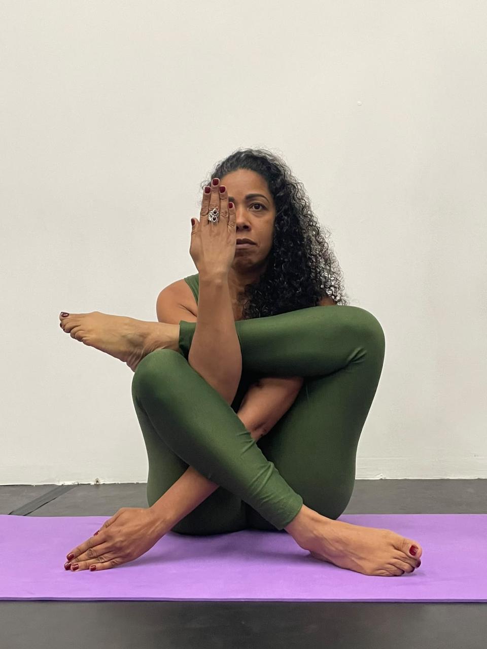 Praticante de yoga em uma postura sentada sobre o tapete
